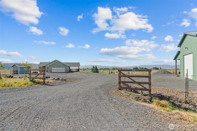 view of street featuring driveway, a rural view, and a gated entry