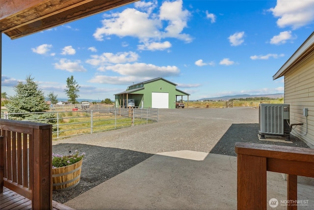 view of yard with a garage, an outbuilding, and central AC