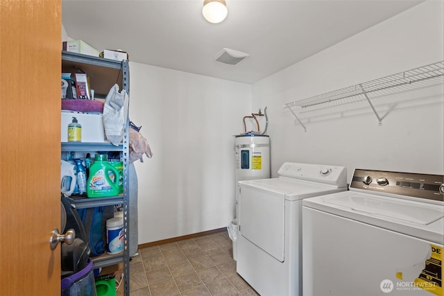 clothes washing area with laundry area, washer and clothes dryer, electric water heater, and baseboards