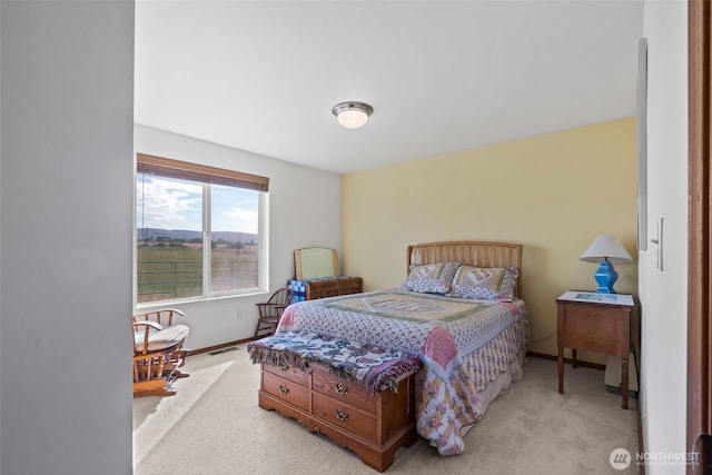 bedroom with baseboards and light colored carpet