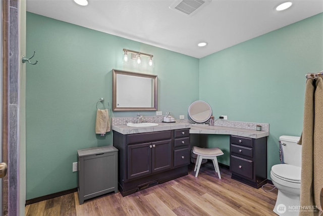 bathroom featuring recessed lighting, visible vents, toilet, vanity, and wood finished floors