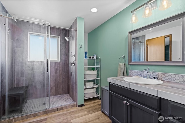 full bath featuring a stall shower, wood finished floors, and vanity