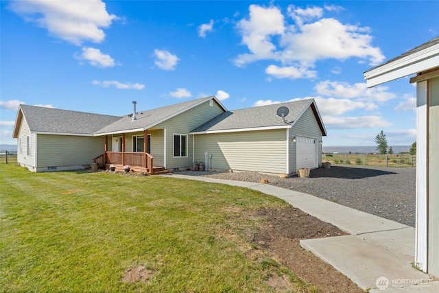 exterior space with covered porch, crawl space, a lawn, and an attached garage