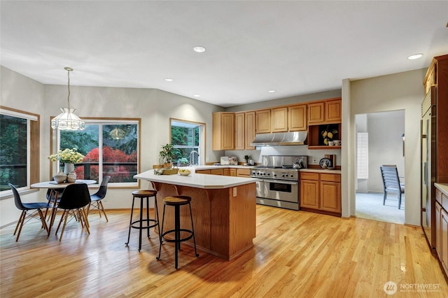 kitchen with light countertops, pendant lighting, double oven range, and under cabinet range hood