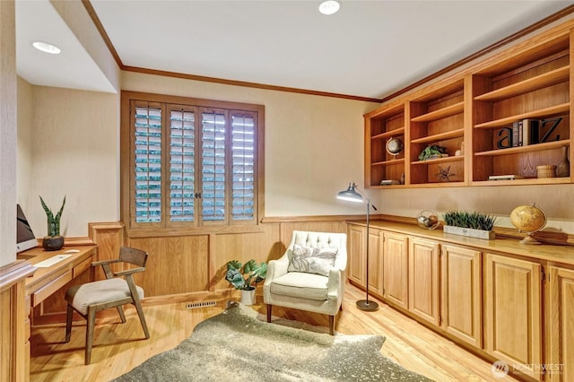 sitting room featuring a wainscoted wall, ornamental molding, visible vents, and light wood-style flooring