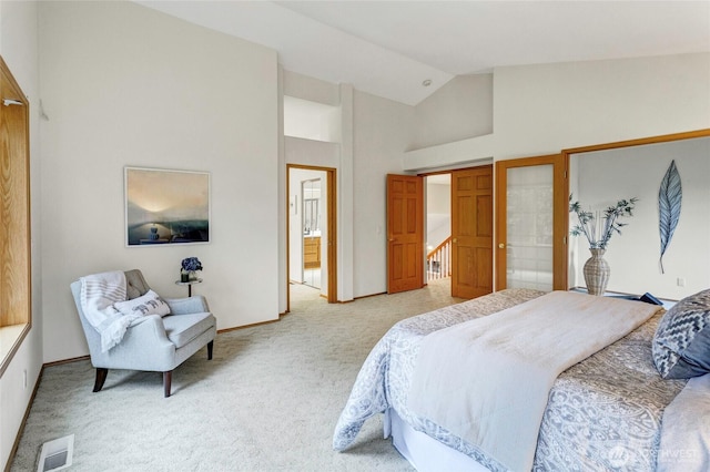 bedroom featuring high vaulted ceiling, connected bathroom, visible vents, and light colored carpet