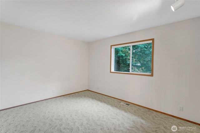 carpeted empty room with baseboards and visible vents