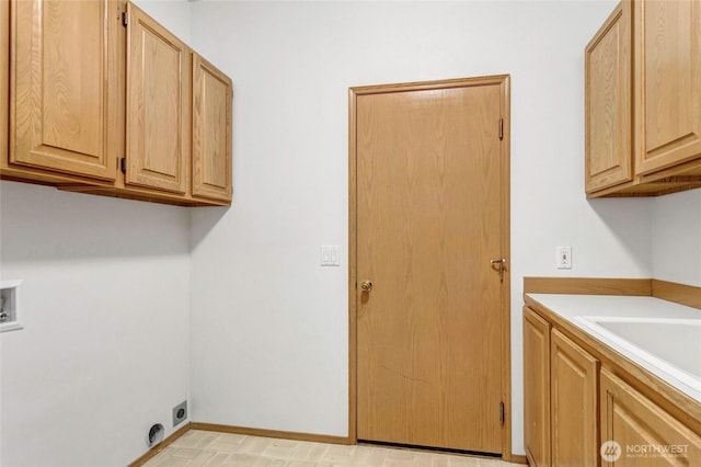 laundry room featuring cabinet space, hookup for a washing machine, baseboards, and a sink