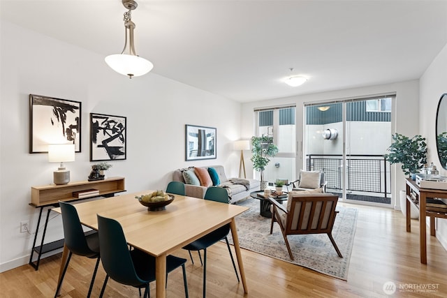 dining space featuring light wood-style flooring and baseboards