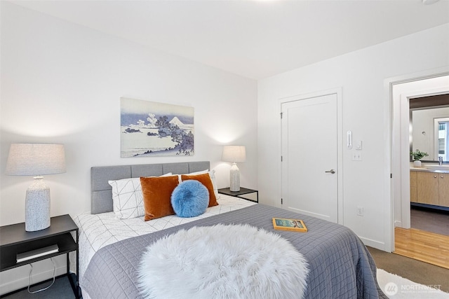 bedroom with baseboards and a sink