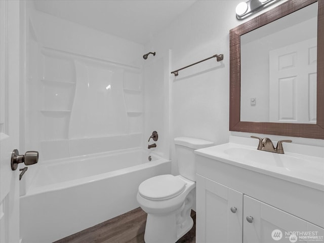 full bathroom with washtub / shower combination, toilet, vanity, and hardwood / wood-style floors