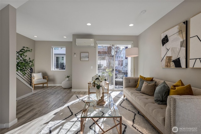 living room featuring a wall mounted AC and light hardwood / wood-style flooring