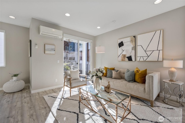 living room with a wall mounted air conditioner and light wood-type flooring