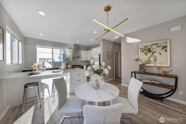 dining space with sink and light hardwood / wood-style floors