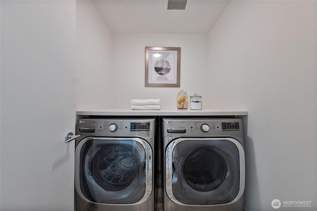 clothes washing area with washer and clothes dryer