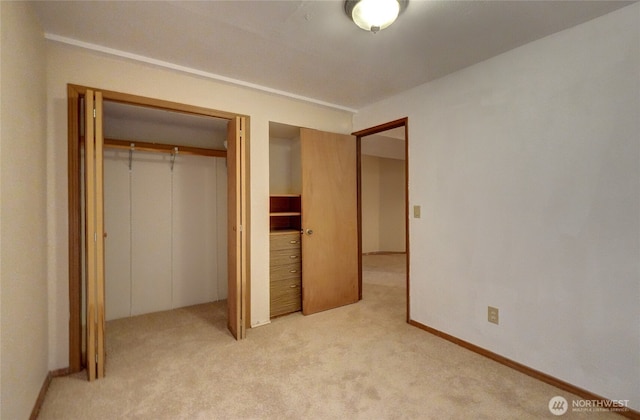 unfurnished bedroom with light colored carpet and a closet