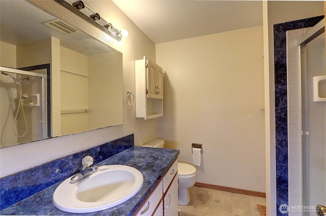 bathroom featuring vanity, toilet, and a shower with door