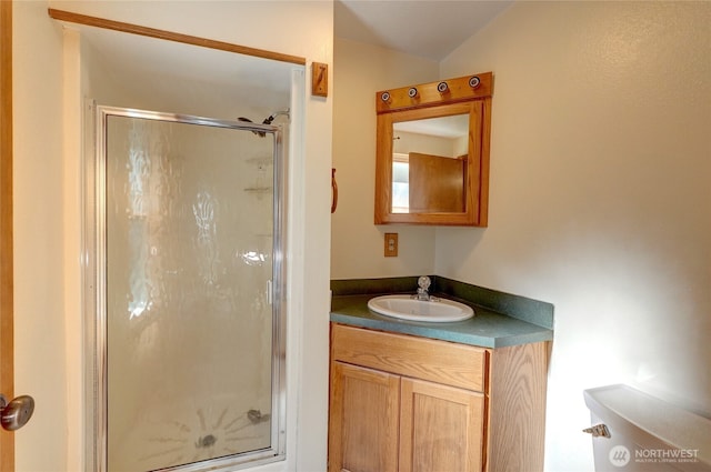 bathroom with vanity, lofted ceiling, toilet, and a shower with shower door