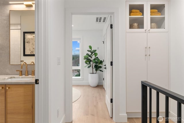 hall with sink and light hardwood / wood-style floors