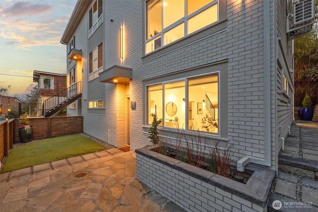 back house at dusk with a patio area