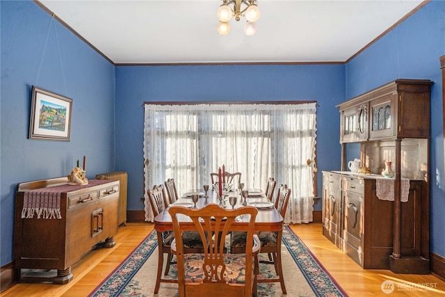 dining room featuring a chandelier, light wood finished floors, and ornamental molding