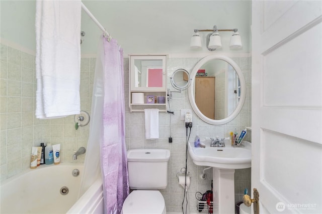 bathroom featuring toilet, tile walls, and shower / bathtub combination with curtain