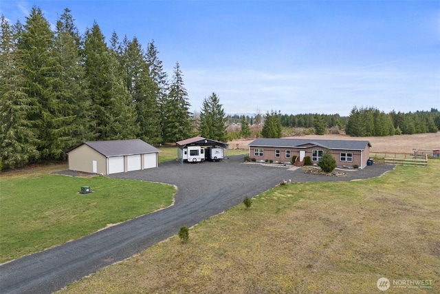 single story home with a front lawn, an outdoor structure, and a garage