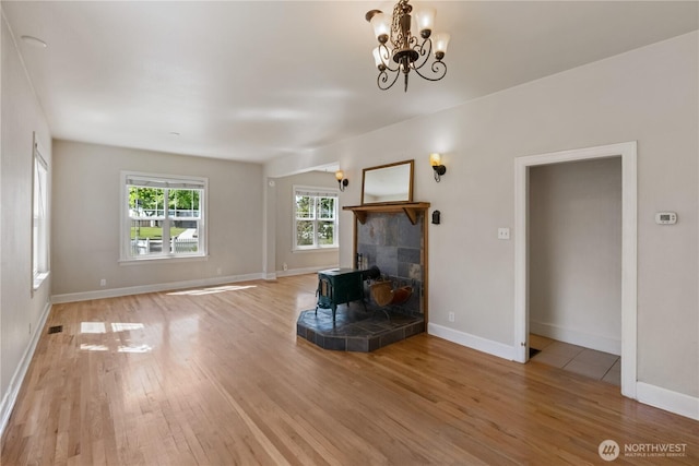 205 S Division, Cashmere, WA 98815 - living room featuring light wood finished floors, a wood stove, a chandelier, and baseboards