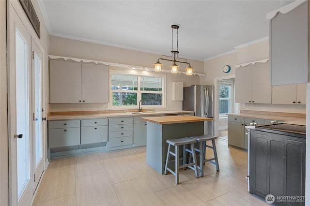 205 S Division, Cashmere, WA 98815 - kitchen featuring a sink, butcher block counters, pendant lighting, crown molding, and a kitchen island