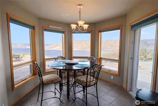 dining space featuring a mountain view, a notable chandelier, baseboards, and plenty of natural light