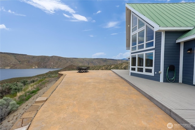 view of patio / terrace with a water and mountain view