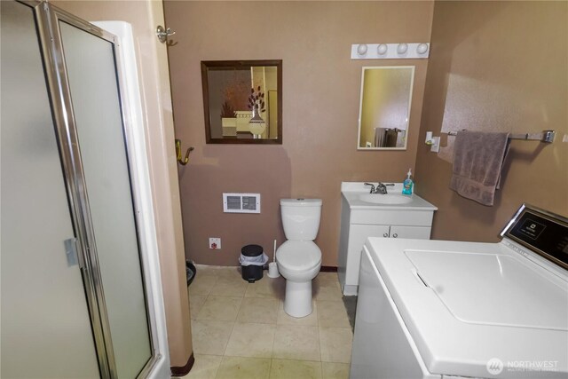 bathroom featuring vanity, visible vents, washer / dryer, a stall shower, and tile patterned flooring