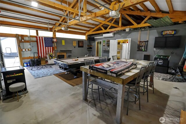 dining space featuring electric panel, lofted ceiling, concrete floors, and a wall unit AC