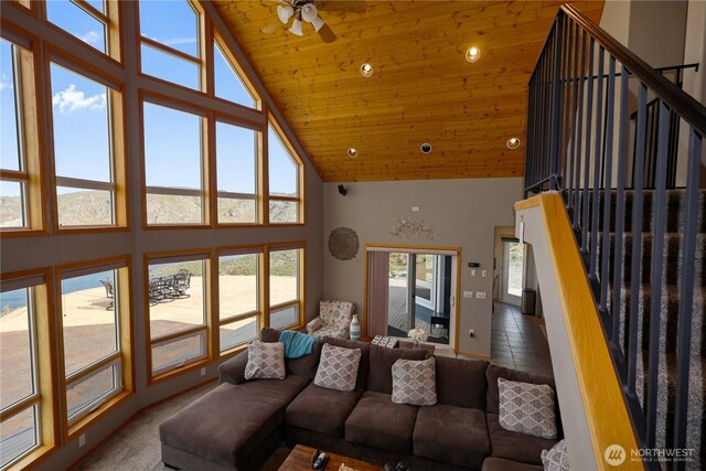 living area featuring a ceiling fan, high vaulted ceiling, wood ceiling, and stairs