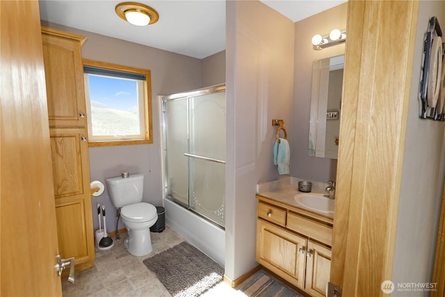 full bathroom featuring shower / bath combination with glass door, baseboards, toilet, and vanity