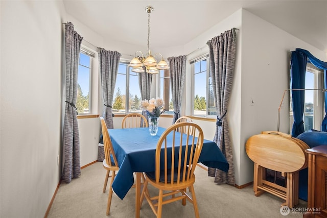 carpeted dining area featuring an inviting chandelier