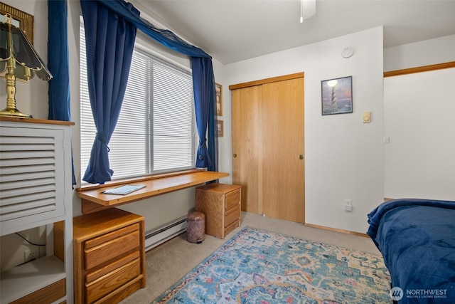 bedroom with a baseboard heating unit, light carpet, and ceiling fan