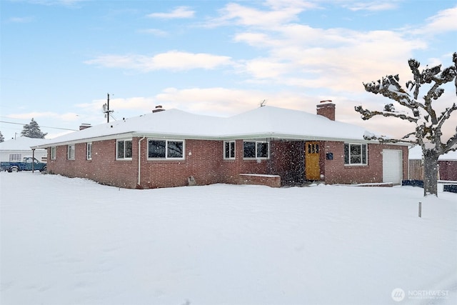 snow covered house with a garage