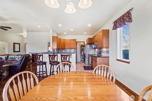 dining space featuring ceiling fan and sink