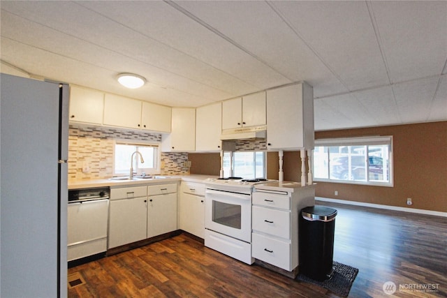 kitchen with sink, white appliances, dark wood-type flooring, white cabinetry, and kitchen peninsula