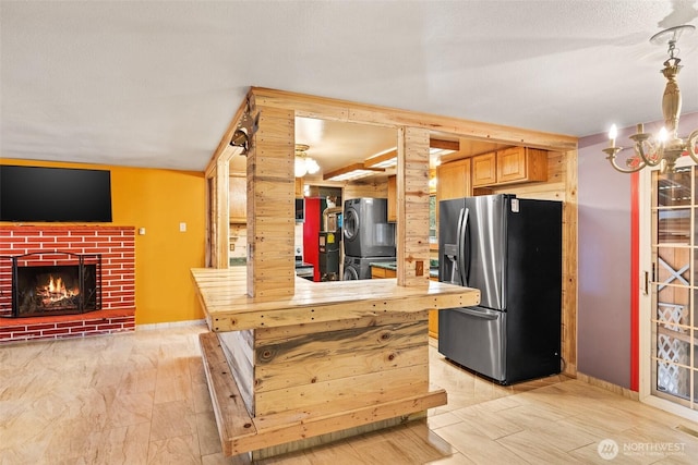 kitchen with a brick fireplace, stainless steel fridge, and refrigerator