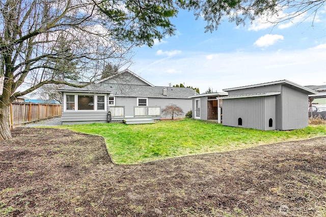 back of house with a yard, an outbuilding, and a deck