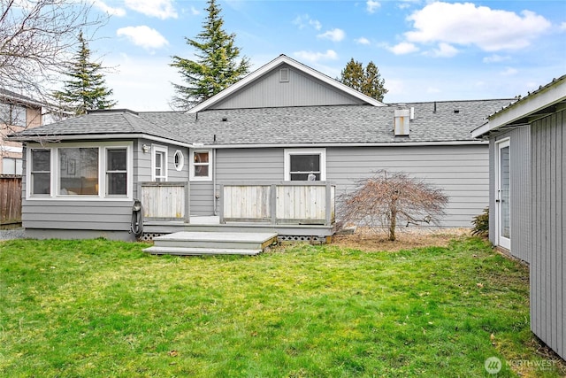 back of property with a yard and a wooden deck