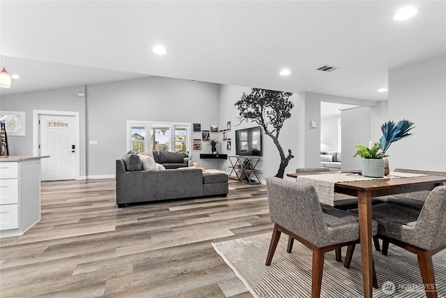 dining area featuring vaulted ceiling and light hardwood / wood-style floors