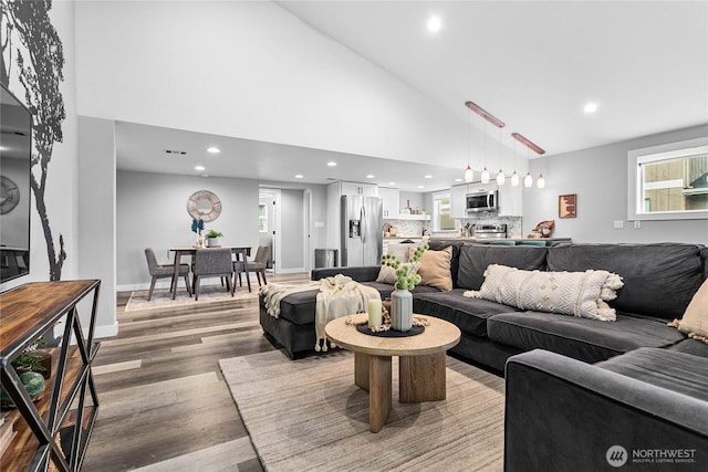 living room featuring hardwood / wood-style flooring and high vaulted ceiling