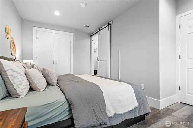 bedroom featuring a closet, hardwood / wood-style flooring, and a barn door