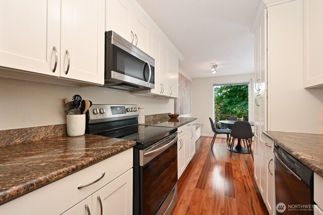 220 SW 200th St Unit 186, Normandy Park, WA 98166 - kitchen with appliances with stainless steel finishes, light wood finished floors, white cabinetry, and dark stone countertops