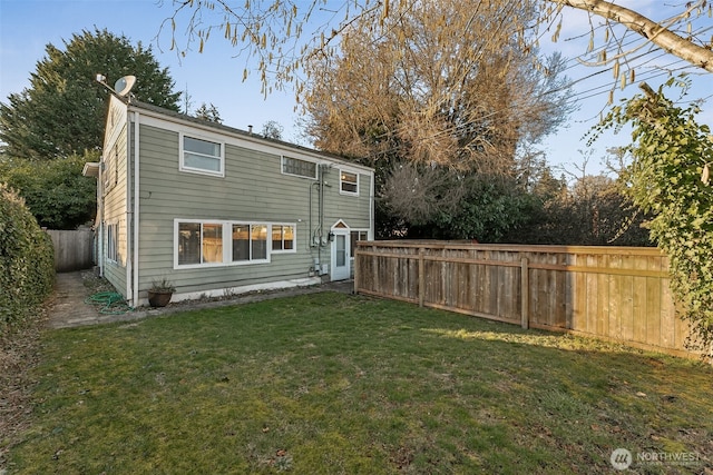 rear view of property featuring a lawn