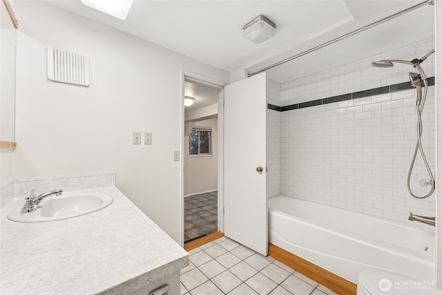 bathroom featuring tiled shower / bath combo, vanity, and tile patterned flooring