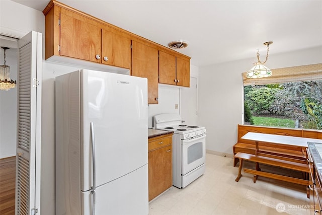 kitchen featuring white appliances and hanging light fixtures